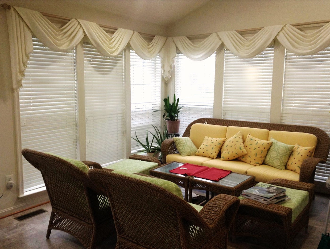 Kings gallery sunroom with cream window swags and upholstered wicker seating